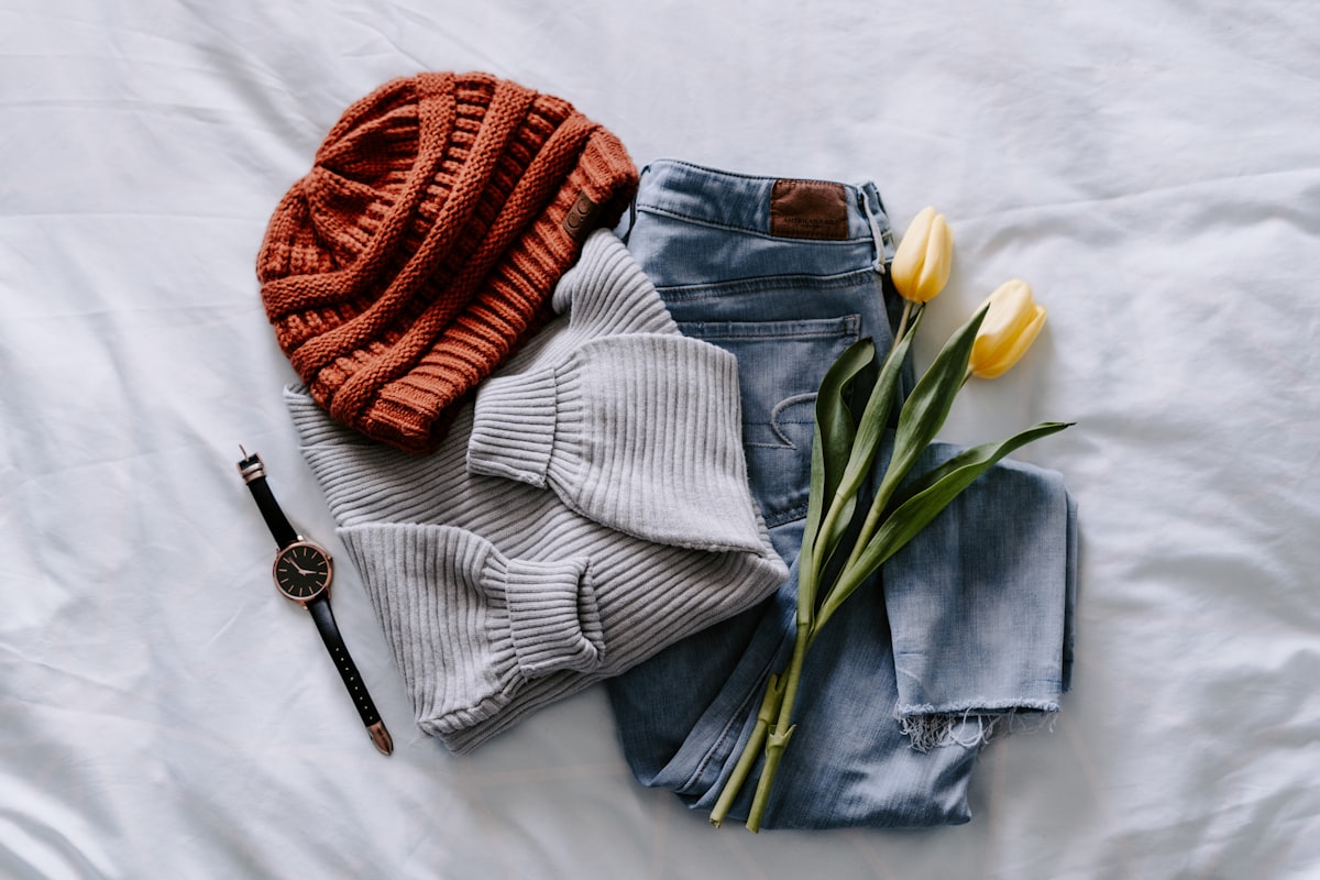 Eigen kledingmerk starten: lessen van Nederlandse merken die het wel haalden - Eigen kledingmerk starten: lessen van Nederlandse merken die het wel haalden Flat-lay van een mini-collectie kleding met accessoires